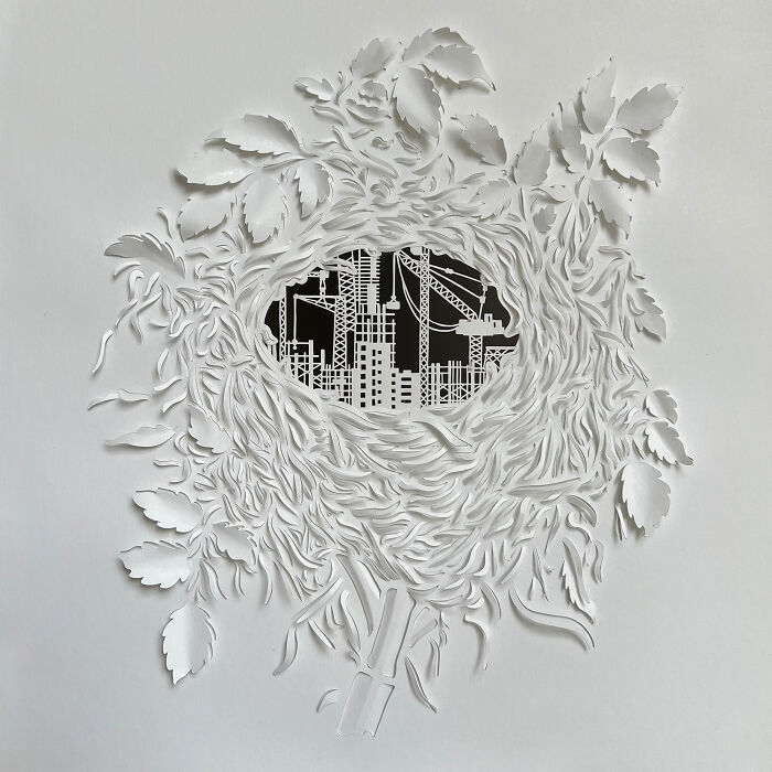 Intricate paper cut design of an urban landscape surrounded by detailed leaf patterns, illustrating tree-less existence.
