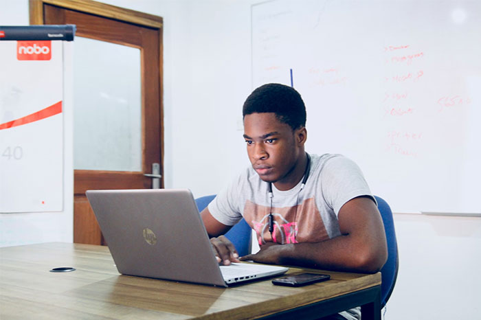 "Person working on a laptop in an office setting, representing people earning $10K and above monthly."