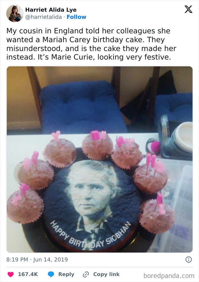 Cake featuring Marie Curie instead of Mariah Carey, surrounded by cupcakes. A hilarious misunderstanding captured perfectly.