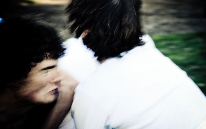 Blurred motion image of two people in an act of sacrifice outdoors.