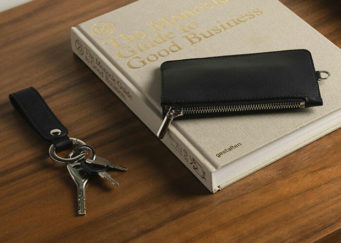 Leather wallet and keys on a wooden table, illustrating practical life hacks.