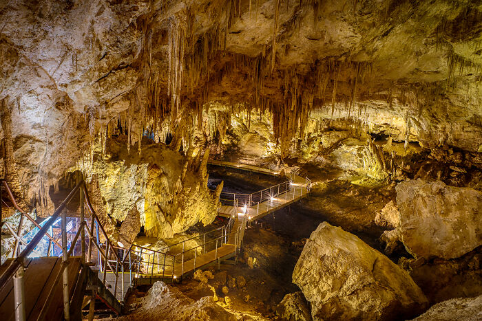 "Amazing views of an illuminated cave interior with formations and pathways in state park."