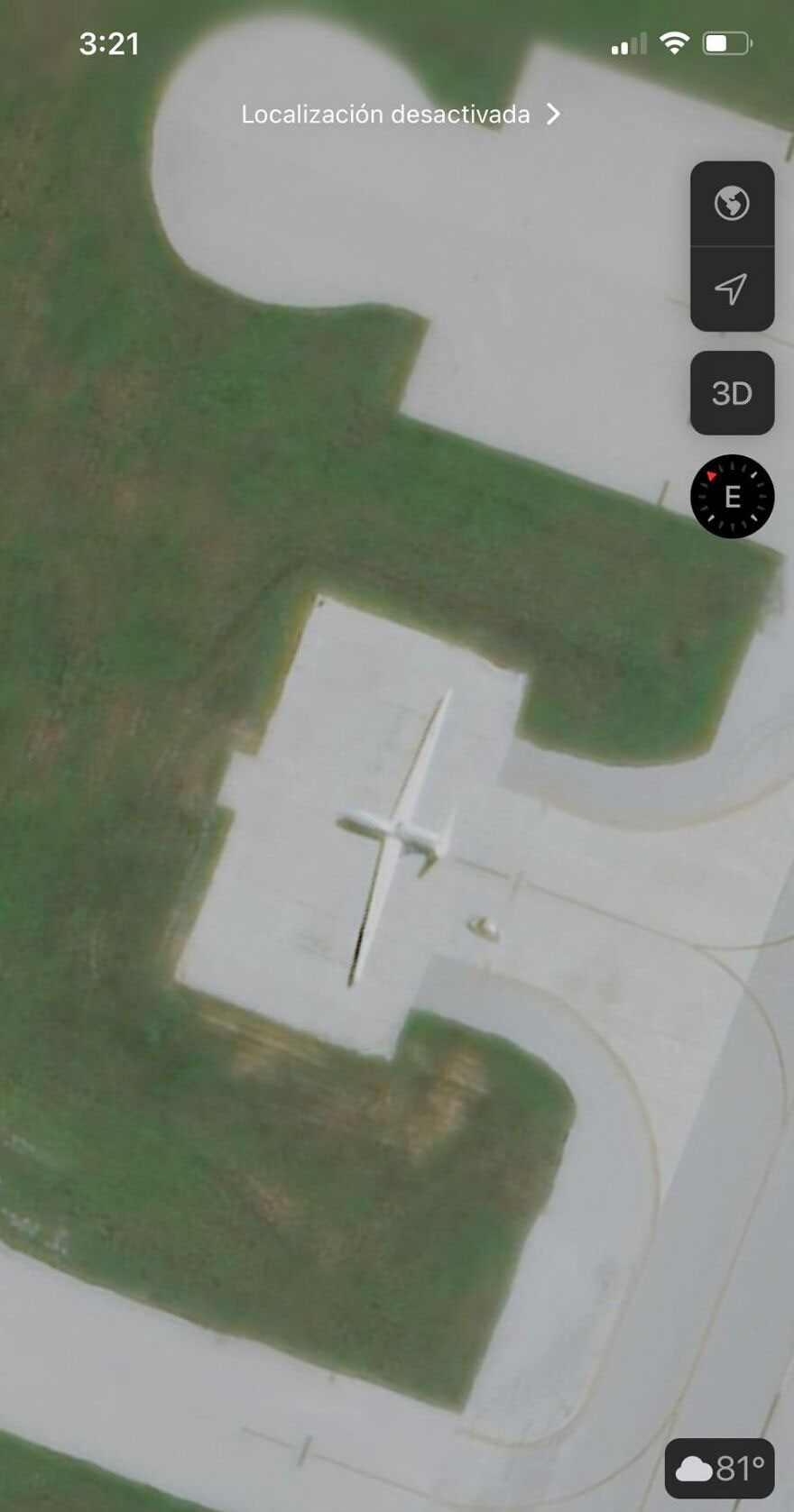 Strange things on Google Earth: satellite view of an airplane-shaped building on a grassy area.