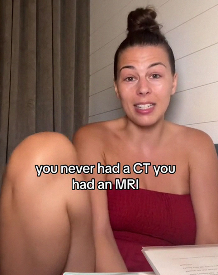 Woman discussing medical binder hack to ensure doctors take her seriously, wearing a red strapless top. Woman discussing medical binder hack to ensure doctors take her seriously, wearing a red strapless top.