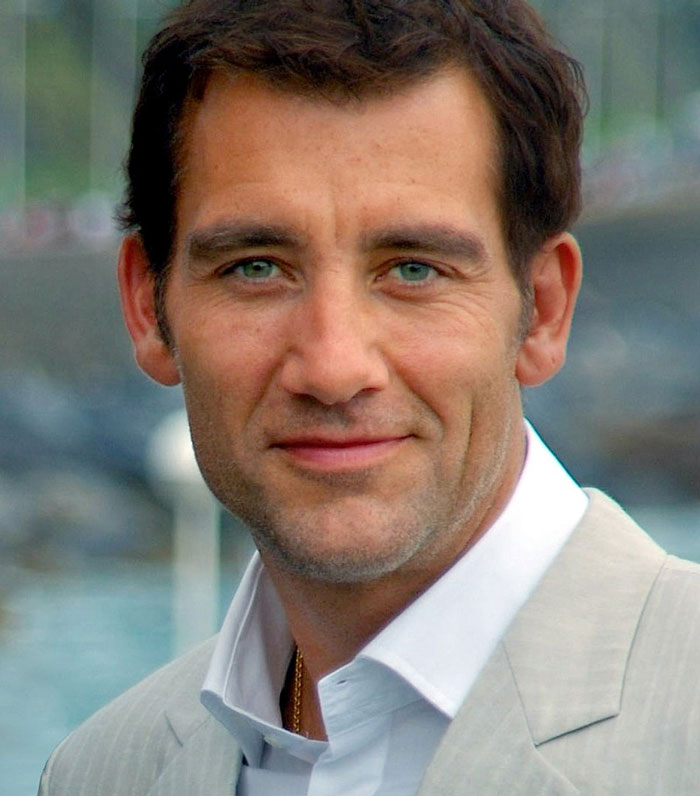 Celebrity in a light suit smiling outdoors, showcasing a setting related to fame.