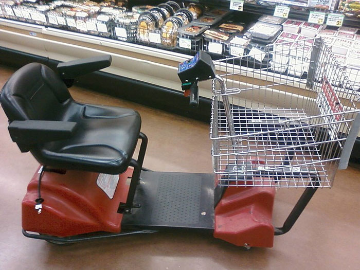 Mobility cart in a grocery aisle at Walmart, highlighting accessibility issues.