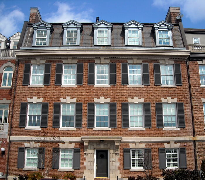 A mysterious brick building with black shutters, associated with unsolved mysteries.