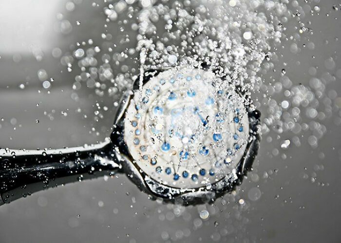 Shower head spraying water, demonstrating popular life hacks for efficient cleaning.