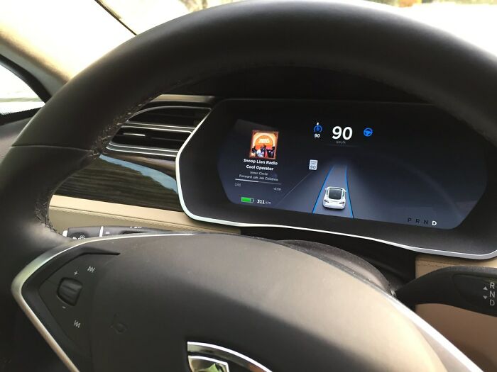 Modern car dashboard with digital interface displaying speed and navigation; represents technology older people refuse to use.