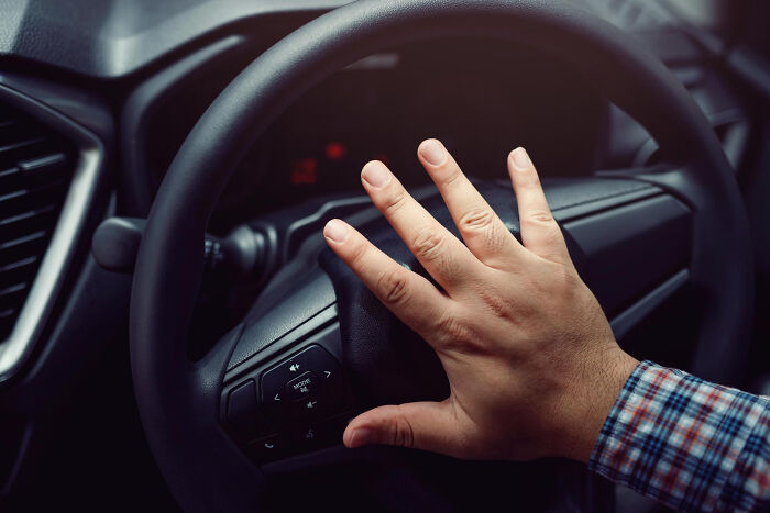 Hand on a car steering wheel, a realization moment about driving habits as an adult.