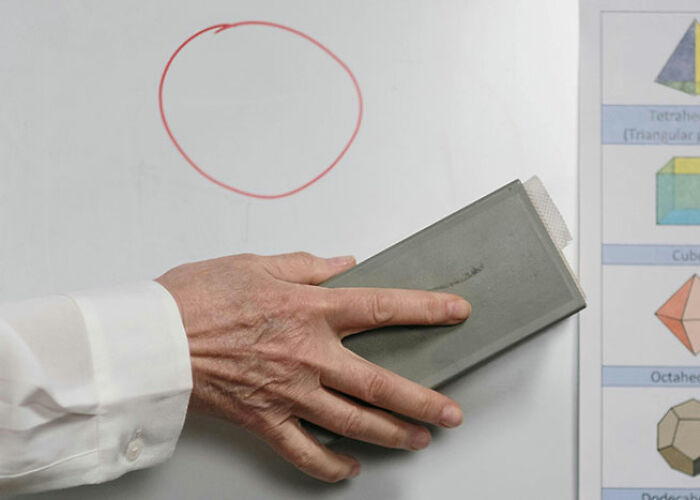 Hand erasing red circle on whiteboard next to geometric shapes, illustrating life hacks.