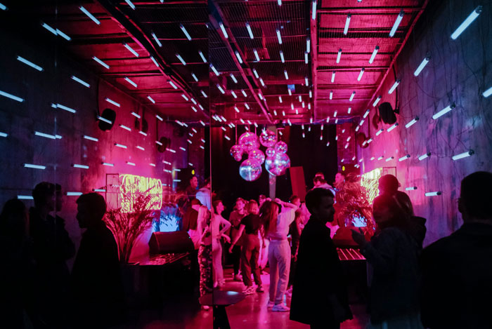 People dancing in a vibrant room with neon lights and disco balls, related to true crime cold cases.