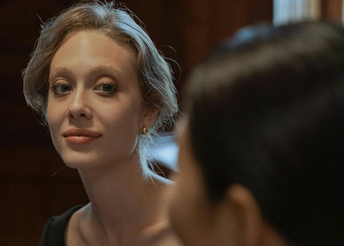 Person smiling softly in warm lighting, showcasing a life hack moment of happiness and confidence.