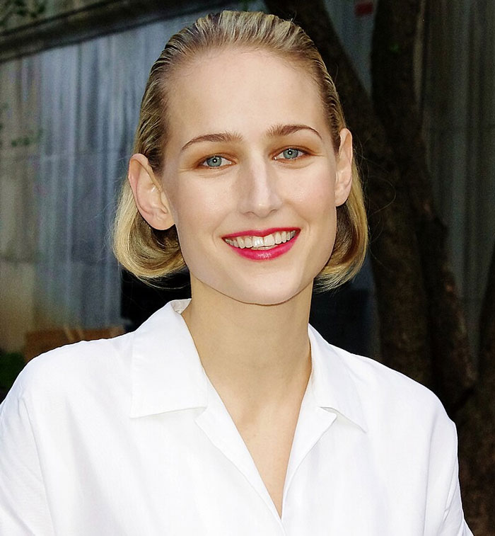 Celebrities smiling in a white shirt, highlighting subtle fame decline.