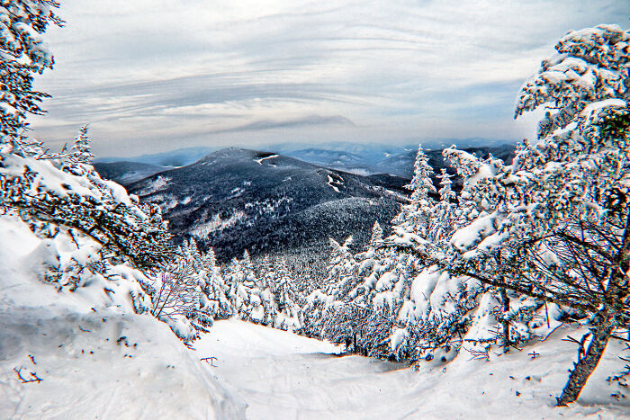 Snowy mountain landscape with trees in a serene state, offering amazing views.