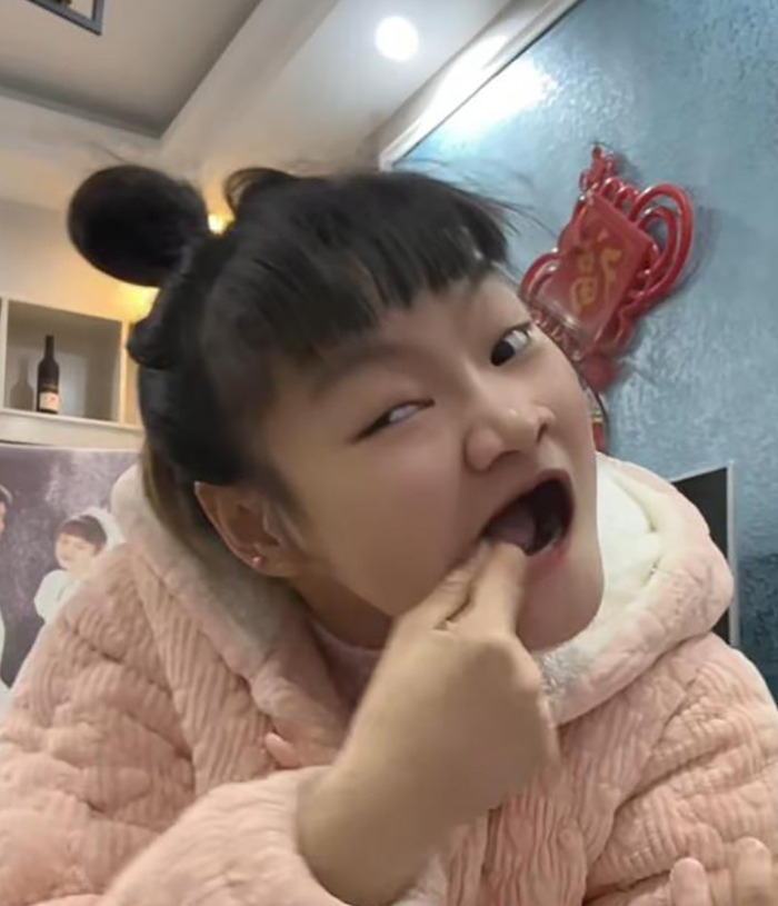 Social media star with cerebral palsy in a pink coat inside a room. Social media star with cerebral palsy in a pink coat inside a room.