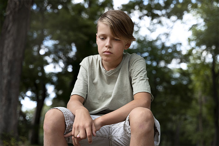Teen sitting outdoors, looking thoughtful, representing refusal to be treated as family's babysitter. Teen sitting outdoors, looking thoughtful, representing refusal to be treated as family's babysitter.