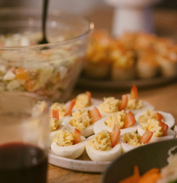 A platter of deviled eggs with sliced tomatoes at a family gathering, featuring dishes people don’t talk about.