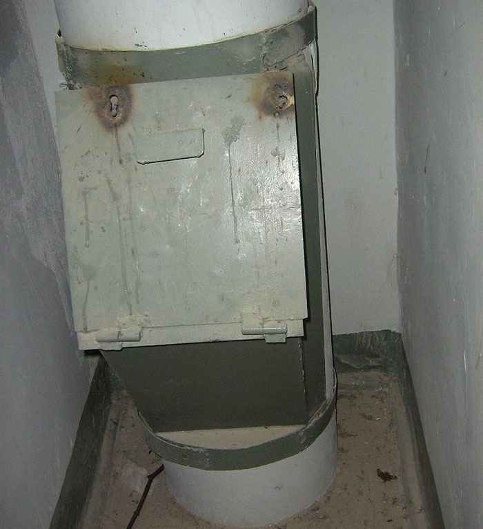 A mysterious metal chute, possibly linked to unsolved true crime cold cases, showing signs of rust and age.