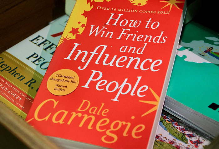 Book titled "How to Win Friends and Influence People" by Dale Carnegie, a classic on quality life improvement hacks.