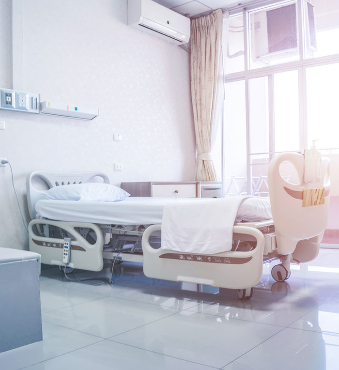 Empty hospital room with a bed and medical equipment behind; NICU setting.