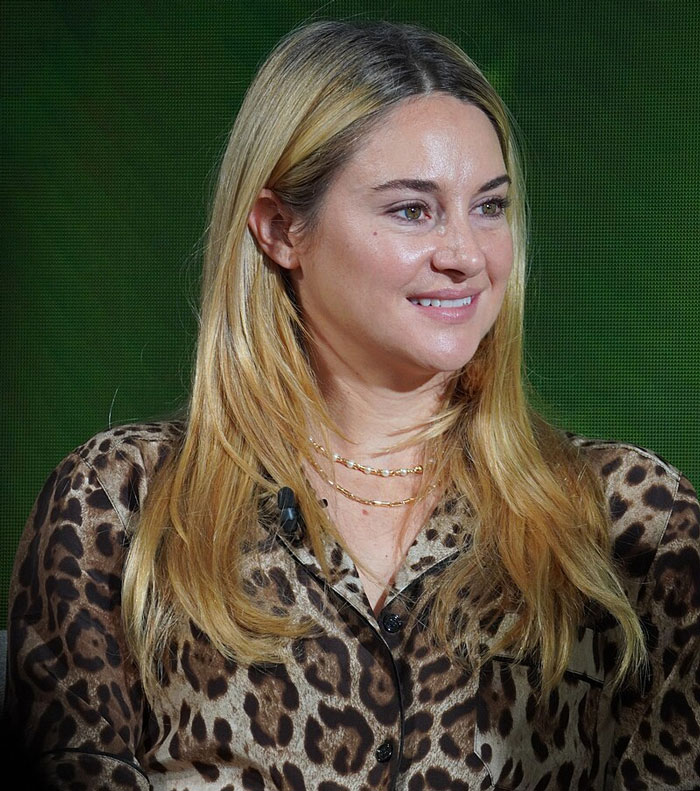 "Celebrity in a leopard print shirt, smiling at an event."