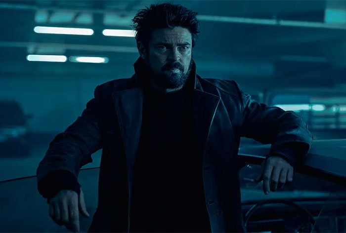 A man in a dark coat, standing in a dimly lit garage, representing celebrities who lost fame.