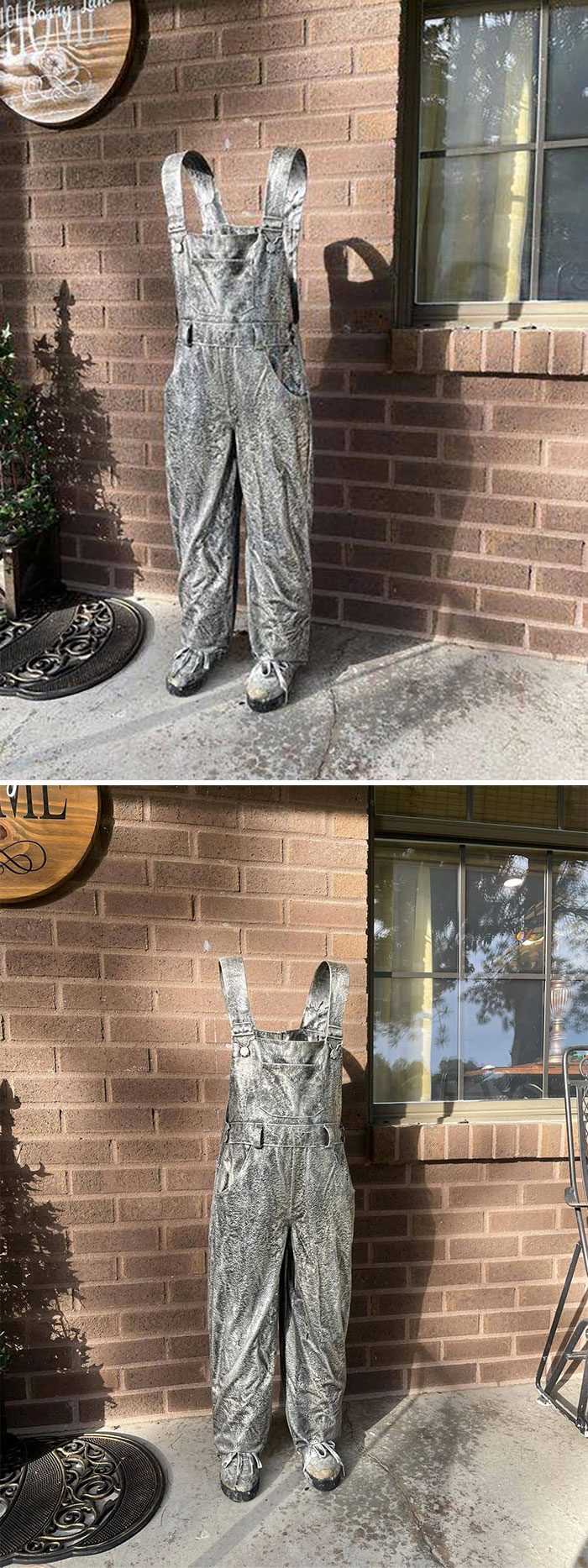 Secondhand find: weathered overalls standing on pavement, resembling an invisible person outside a brick wall and window.