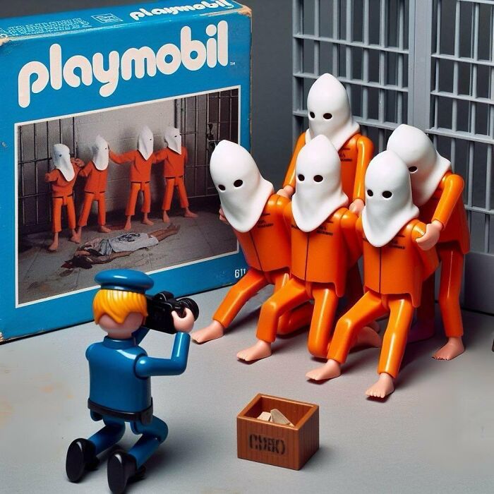 Controversial toy scene with hooded figures in orange, photographed by a blue-clad toy figure, box nearby.