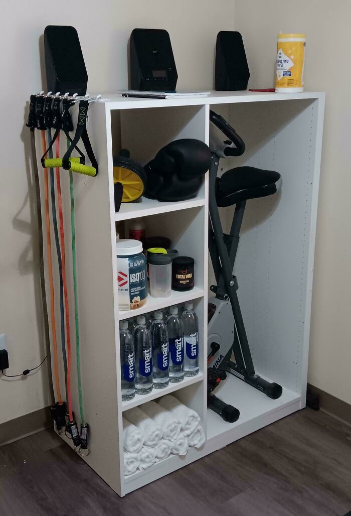 Neat results of next-level organization with workout gear, neatly stacked bottles, and folded towels on a shelf.