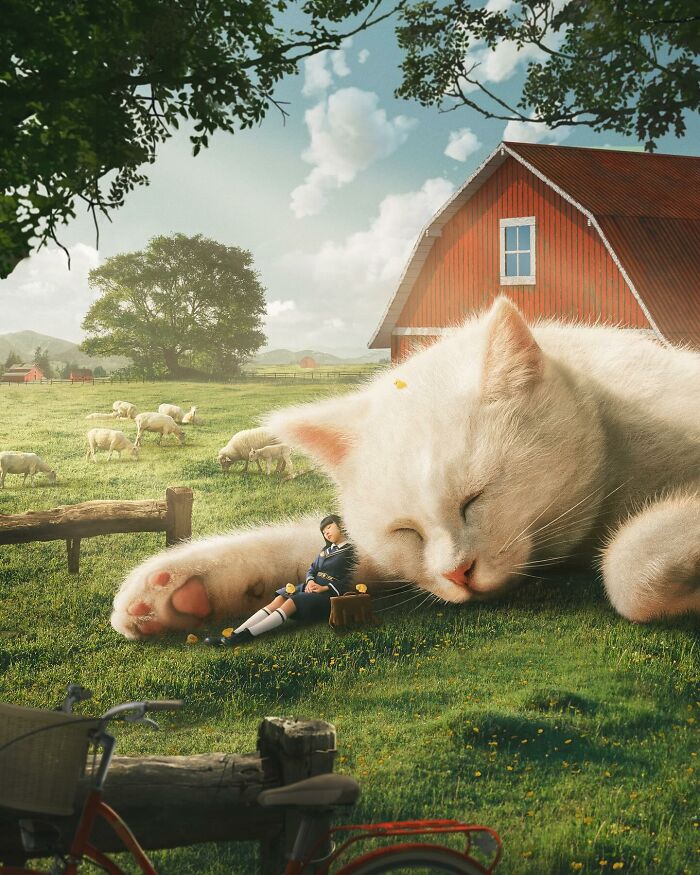 Giant cat sleeping on a sunny farm with sheep grazing and a person resting against its paw.