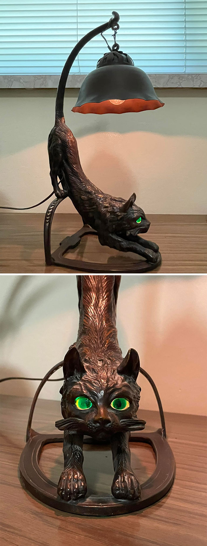 Weird secondhand find: Cat-shaped lamp with glowing green eyes on a wooden table.