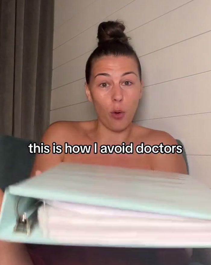 Woman showing her medical binder hack to ensure doctors take her seriously. Woman showing her medical binder hack to ensure doctors take her seriously.