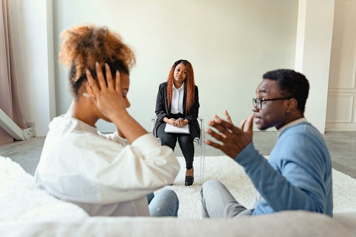 Couple in therapy session discussing cheating partner and dealing with consequences.