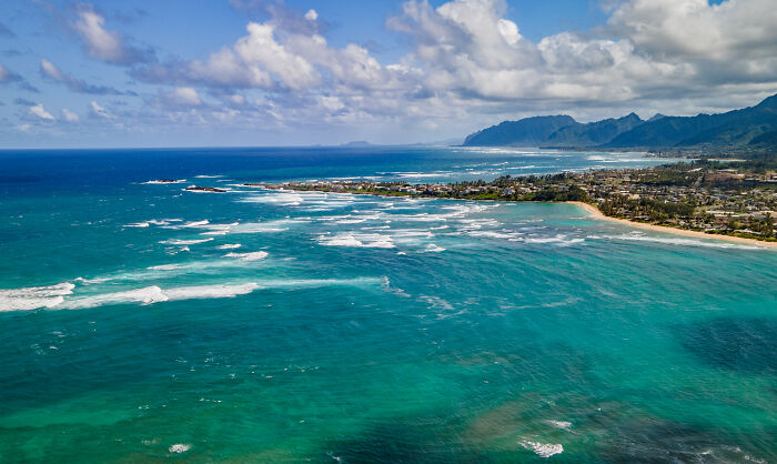 Aerial view of a stunning coastal landscape, showcasing amazing views and natural beauty with blue ocean waves and a horizon.
