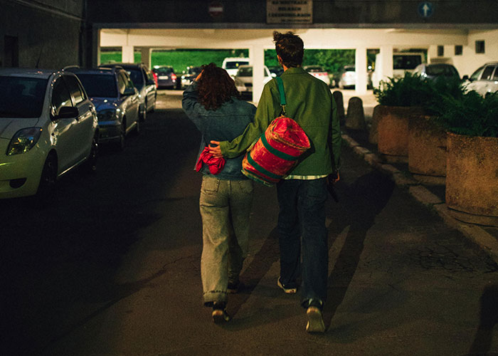 Couple walking with arms around each other in a parking garage, highlighting a different connection.