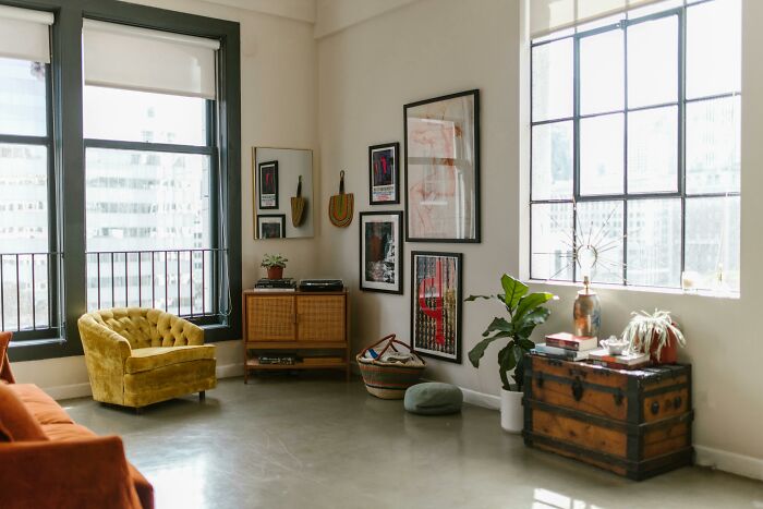 Interior decor with a yellow armchair and framed art enhances home living, reflecting improved life quality.