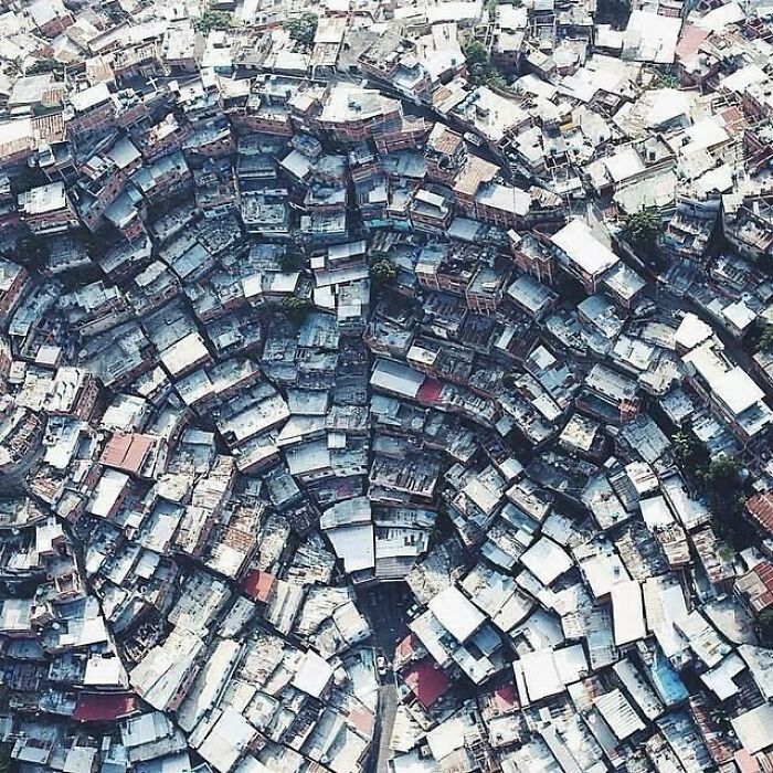 Aerial view of densely packed urban area forming a circular pattern, depicting urban hell.