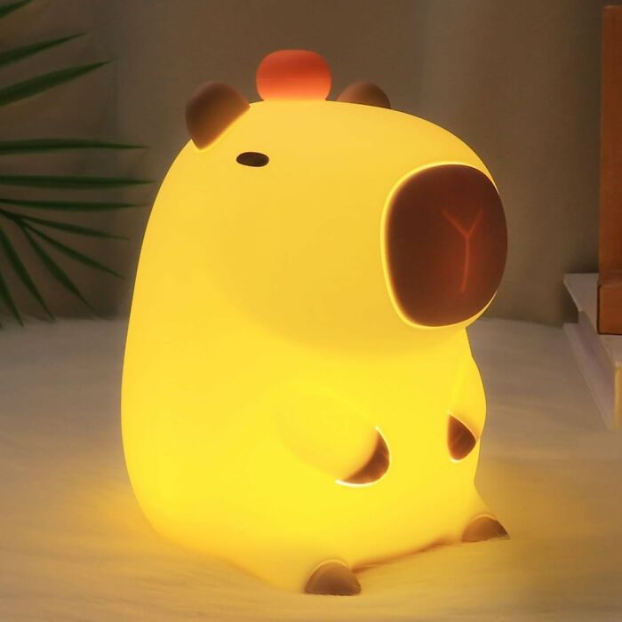 Glowing capybara-shaped lamp, a funny Amazon find, illuminating a cozy room.