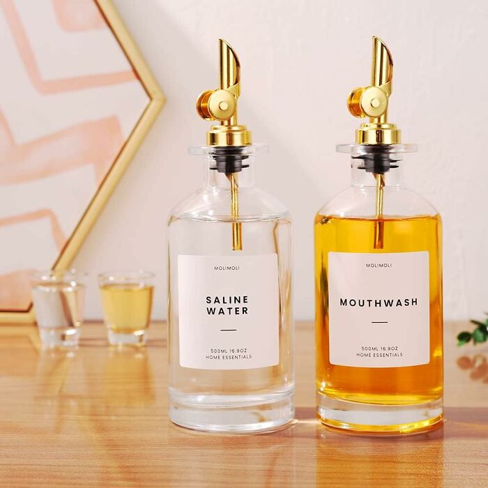 Glass bottles labeled saline water and mouthwash on a wooden surface for banishing eyesores in the home.