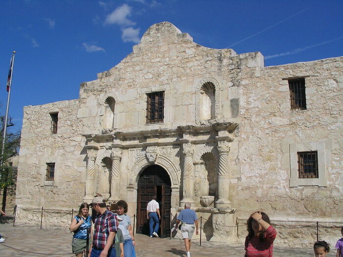 Historic stone building with visitors entering, illustrating facts you weren’t taught in school about the past.