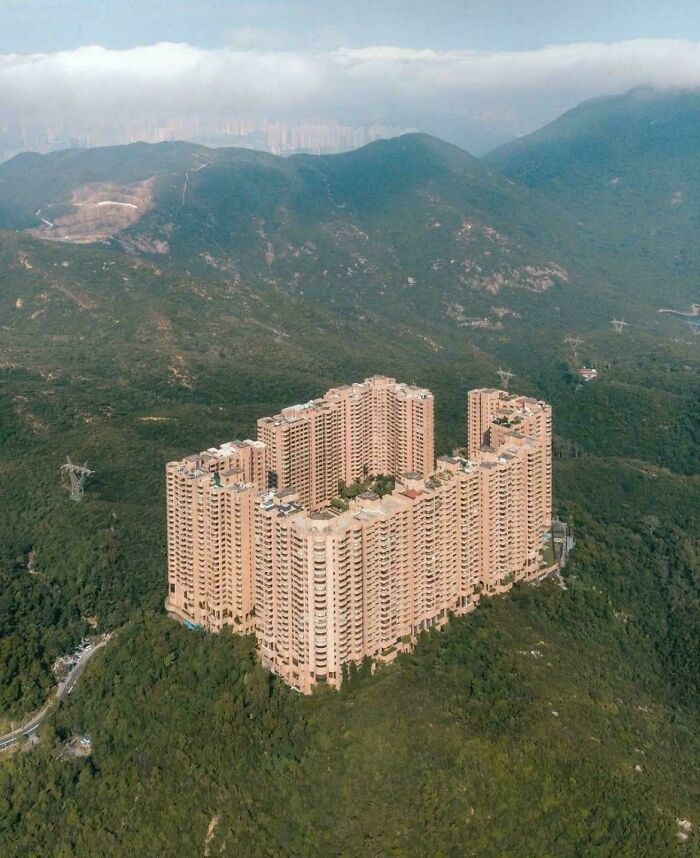 Massive urban buildings surrounded by greenery on a hillside, showcasing an urban hell contrast.