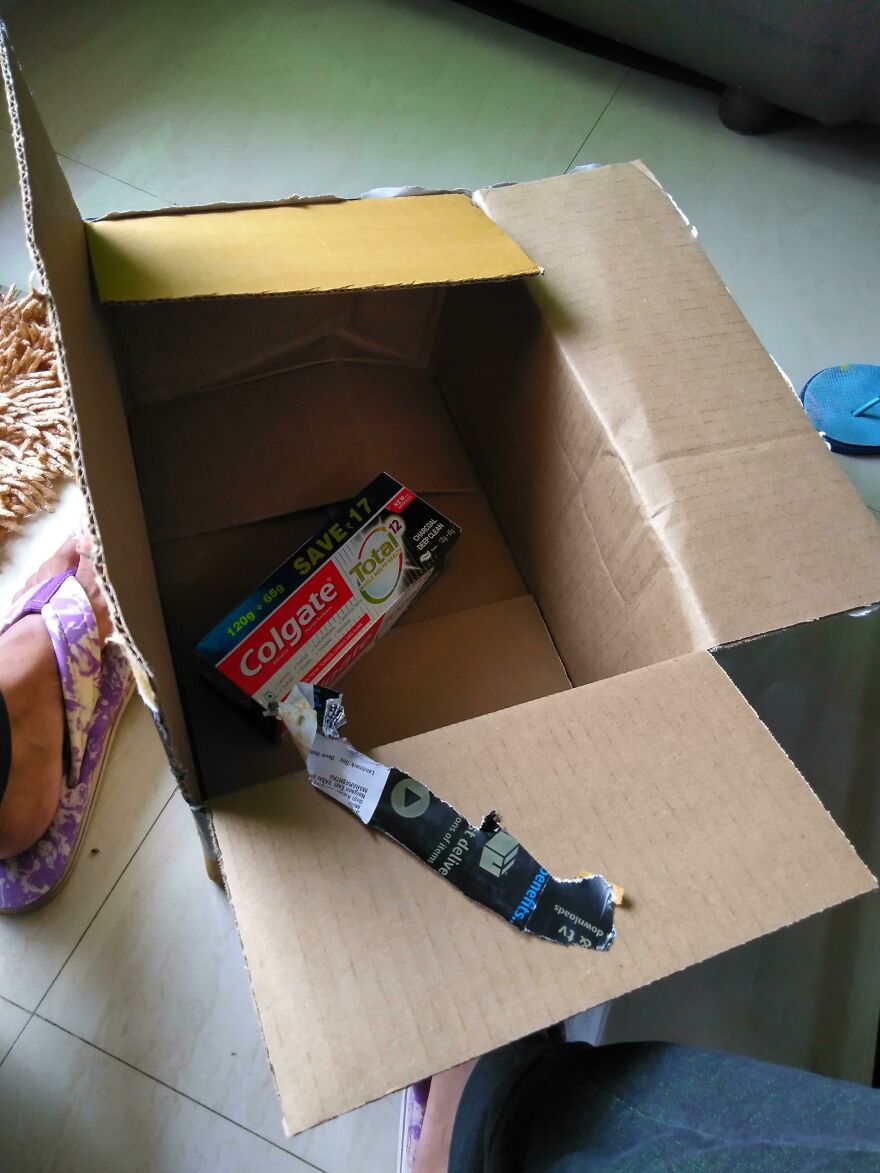 Oversized box with a single toothpaste tube inside, illustrating wasteful packaging.