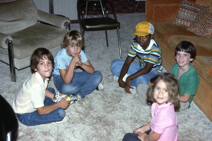 Children sitting in a circle on a carpeted floor, capturing a moment from fascinating historical pics.