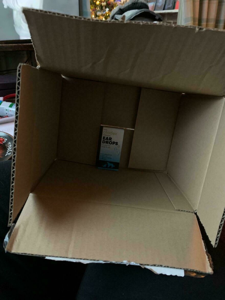 Large empty box with a small bottle of ear drops, illustrating wasteful unnecessary packaging.