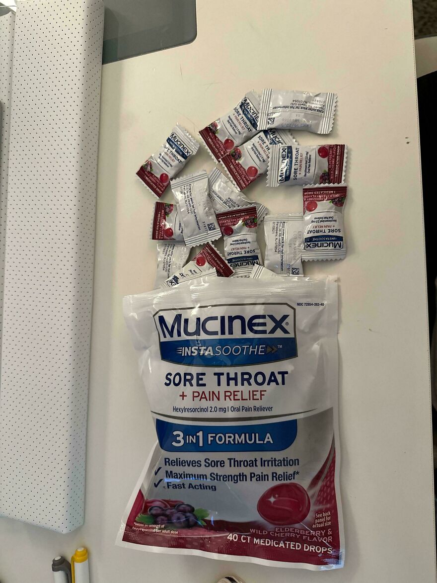 Mucinex sore throat lozenges with wasteful unnecessary packaging on a white table.