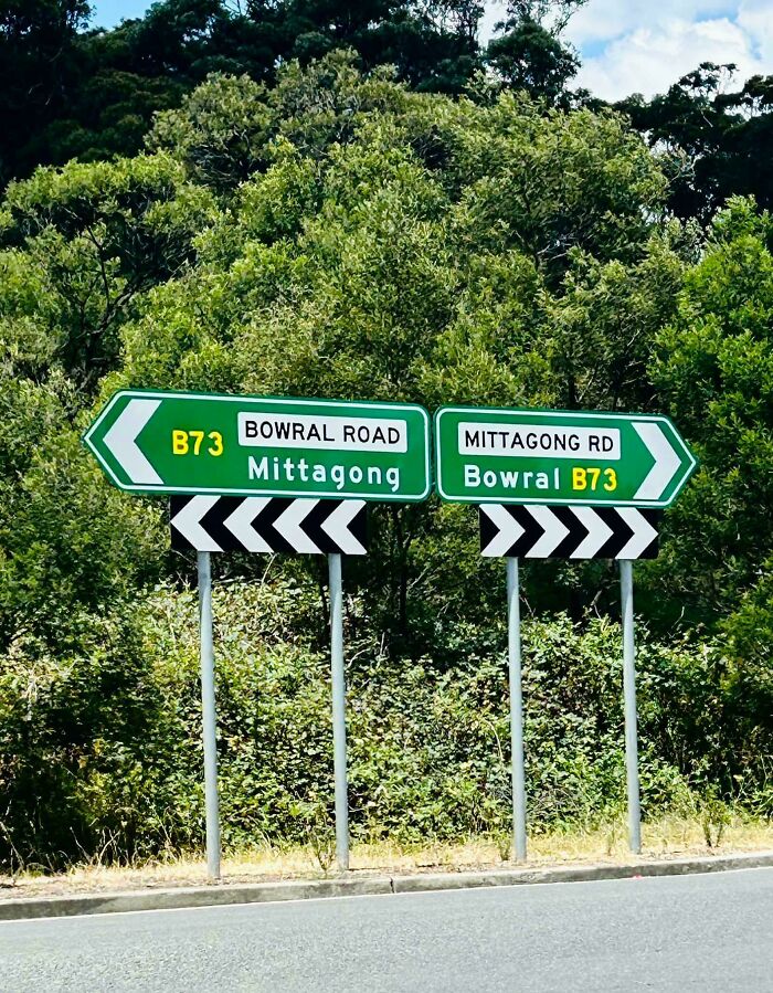 Road signs in Australia showing directions to Bowral and Mittagong surrounded by greenery.