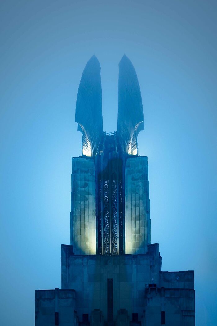 Gothic style building with glowing lights on top creating an evil aura, resembling a supervillain headquarters at dusk.