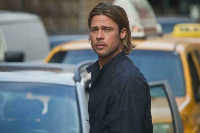 Brad Pitt standing among cars on a city street in a scene highlighting questionable movie details that cinephiles mock online.