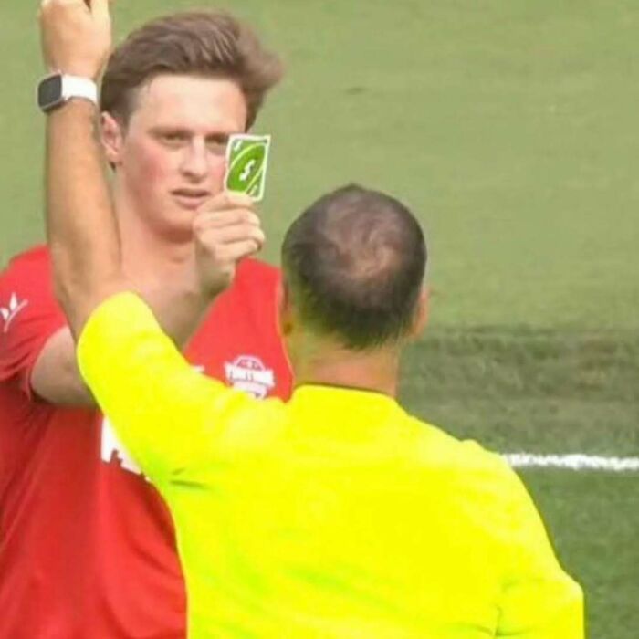 Referee showing a green card to a player during a soccer match in a random photos collection for processing.